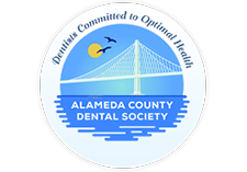 The image shows a logo with text that reads 'ALAMEDA COUNTY DENTAL SOCIETY' and features an illustration of a bridge over water, with a sunset on the horizon in the background.