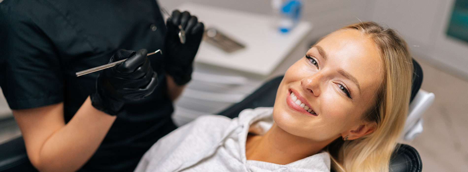 The image shows a modern dental clinic interior with various pieces of equipment, including a dental chair and an X-ray machine.