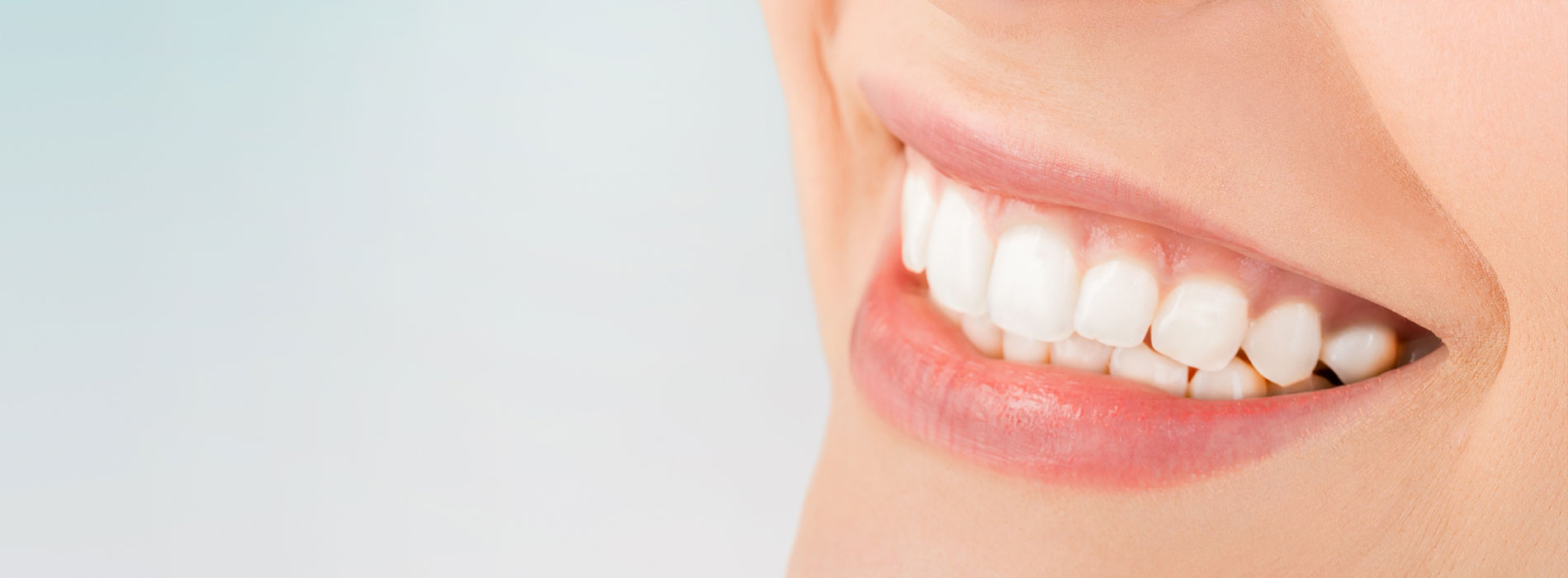 The image shows a group of people, possibly professionals given their attire and the setting that appears to be an office or professional environment. They are gathered around a table with a laptop on it, engaged in what seems to be a discussion or meeting.